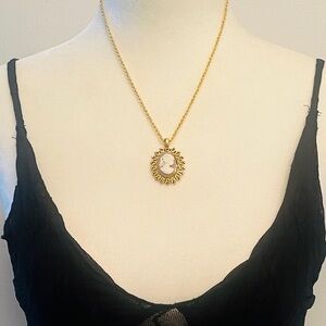 Vintage cameo featuring a carved portrait set within an ornate gold-tone frame.